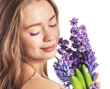 Beautiful young woman with hyacinth flowers on white backgroundの写真素材