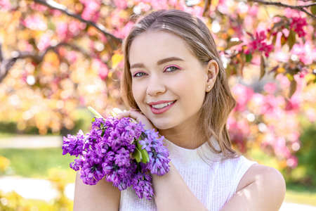 Beautiful young woman with hyacinth flowers outdoorsの写真素材