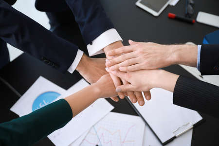 Team of business people putting hands together during meeting in officeの写真素材