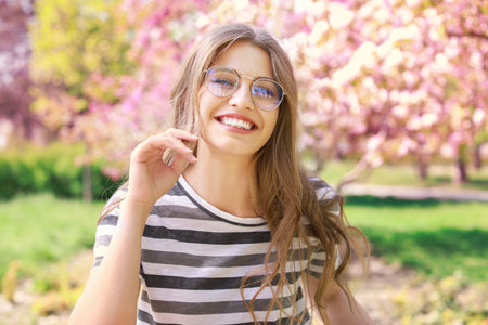 Beautiful young woman in park on spring day