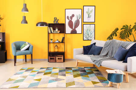 Stylish interior of living room near color wall