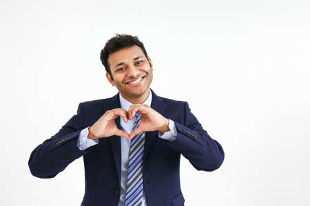 Handsome businessman making heart with his hands on white backgroundの写真素材