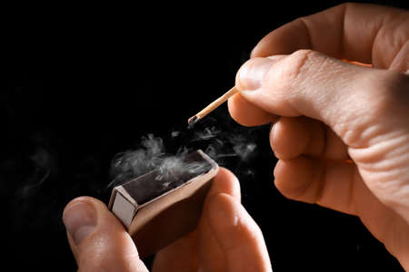Man striking match on dark backgroundの写真素材