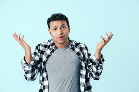 Handsome confused man on color backgroundの写真素材