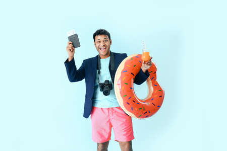 Funny office worker with passport, cocktail and swimming ring dreaming about vacation on color...