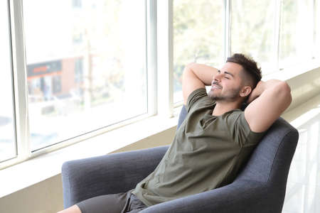 Handsome man resting in armchair at homeの写真素材