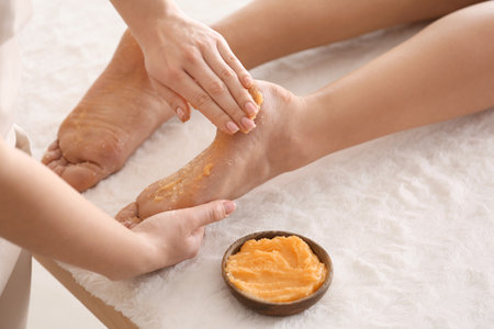 Young woman undergoing treatment with body scrub in spa salonの写真素材