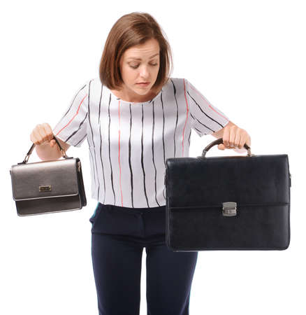 Sad businesswoman with different bags on white background. Concept of balance between work and leisureの写真素材