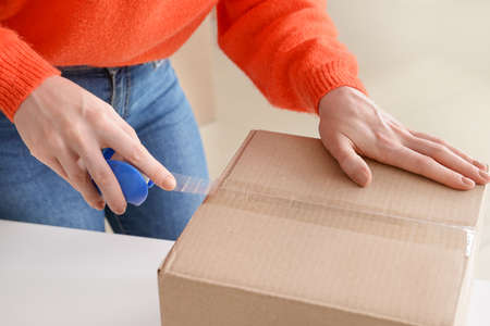 Young woman packing box, closeup