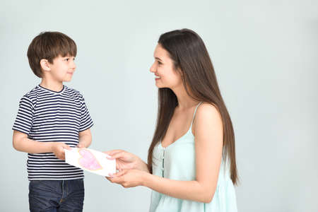 Son greeting his mother on gray backgroundの写真素材