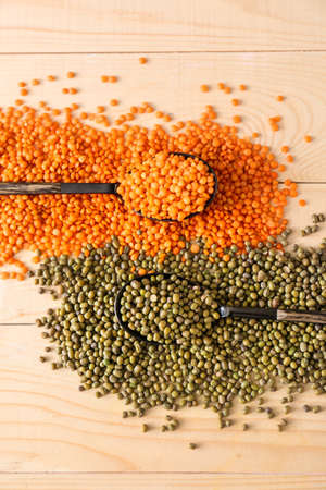 Raw lentils with mung beans on wooden tableの写真素材