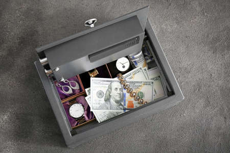Small modern safe with valuables on gray backgroundの写真素材