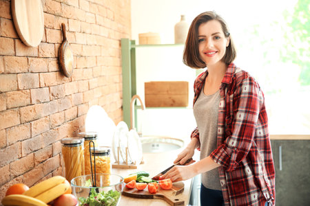 Beautiful young woman cooking in kitchenの写真素材