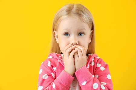 Portrait of adorable little girl on color backgroundの写真素材