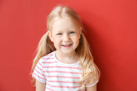 Portrait of adorable little girl on color backgroundの写真素材