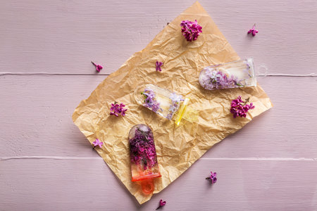 Floral ice cream with fresh lilac flowers on wooden table