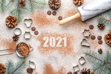 New Year composition with cookie cutters and cacao powder on gray background