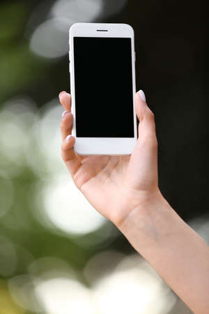 Young woman with mobile phone outdoorsの写真素材