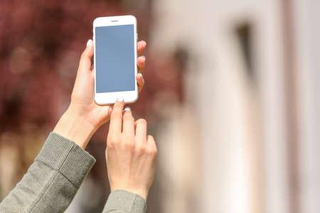 Young woman with mobile phone outdoorsの写真素材
