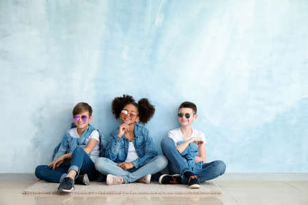 Stylish children in jeans clothes near color wallの写真素材
