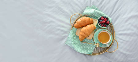 Tray with tasty breakfast on bedの写真素材