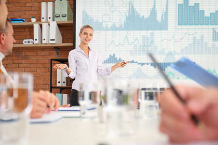 Businesswoman giving presentation during meeting in office