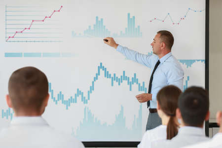Mature businessman giving presentation during meeting in office