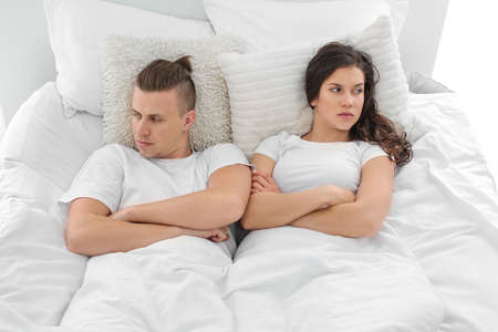 Young couple after quarrel lying in bed