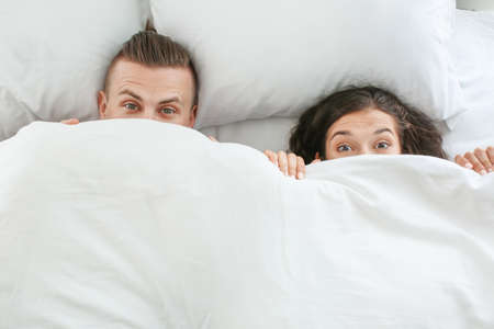 Adorable loving couple lying in bedの写真素材