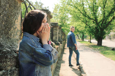 Sad young girlfriend after quarrel with her boyfriend outdoorsの写真素材