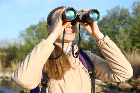 Female tourist with binocular enjoying the beauty of natureの写真素材