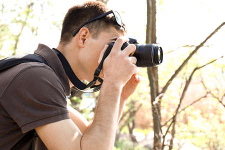 Male tourist taking photo in forest