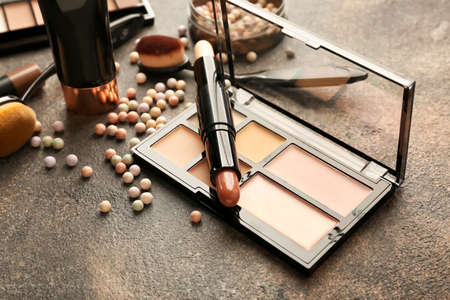 Set of cosmetics for contouring makeup on gray background
