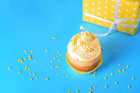 Tasty Birthday cupcake on color backgroundの写真素材