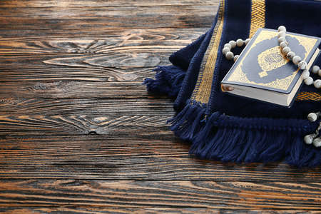Muslim prayer mat, beads and Koran on wooden backgroundの写真素材