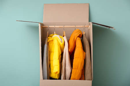Wardrobe box with clothes on color backgroundの写真素材