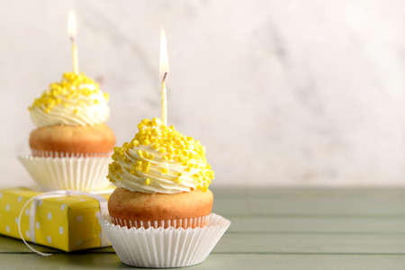 Tasty Birthday cupcakes with gift box on table