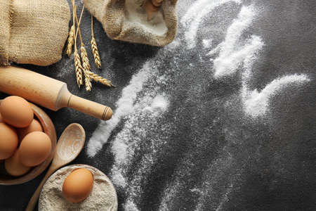 Flour with eggs on dark background