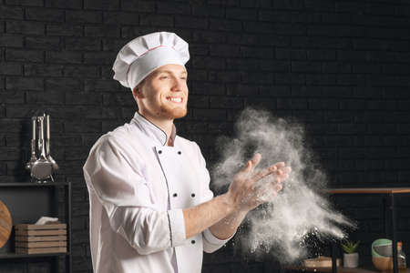 Male chef clapping hands with flour in kitchen