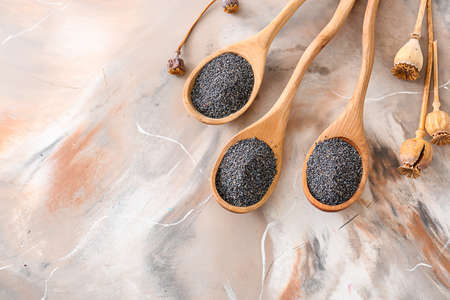 Spoons with poppy seeds on tableの写真素材