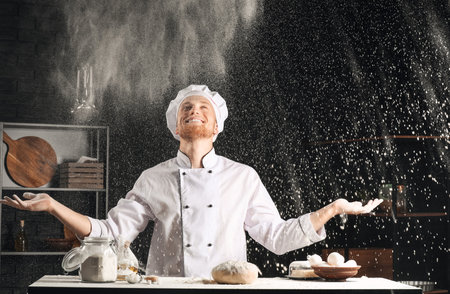Male chef making dough in kitchenの写真素材