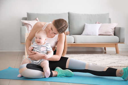 Mother training with cute little baby at homeの写真素材