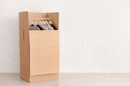 Wardrobe box with clothes near white wallの写真素材