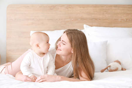 Happy mother with cute little baby at homeの写真素材