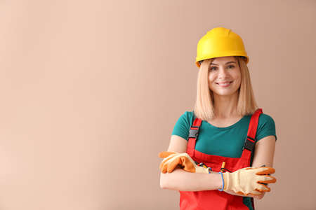 Female carpenter on color background