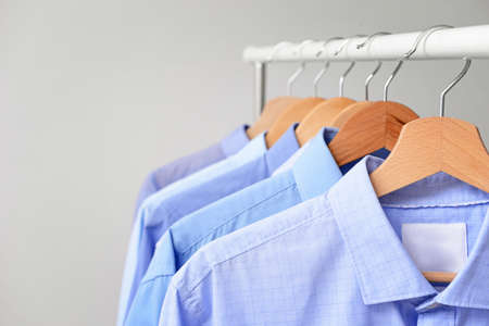 Rack with clothes after dry-cleaning on light background, closeupの写真素材