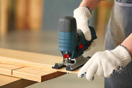 Female carpenter working in shop, closeup