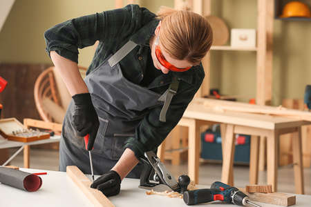 Female carpenter working in shop