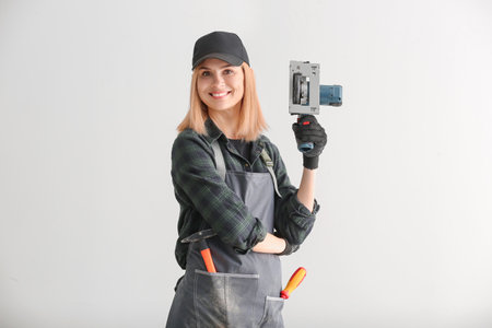 Female carpenter on light backgroundの写真素材