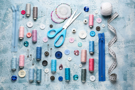 Set of sewing threads and accessories on color background